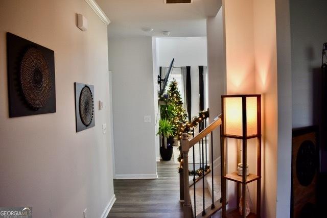 hall with dark wood-type flooring, stairway, and baseboards