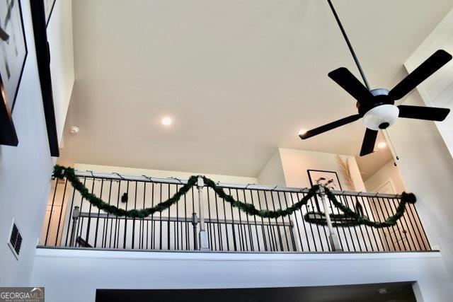 interior space with a gate and a ceiling fan