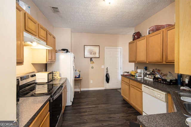 kitchen featuring dark countertops, visible vents, dark wood-type flooring, white appliances, and under cabinet range hood