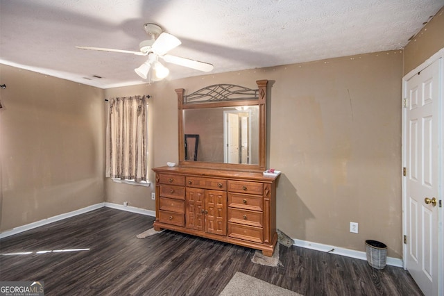 bedroom with a textured ceiling, baseboards, and wood finished floors