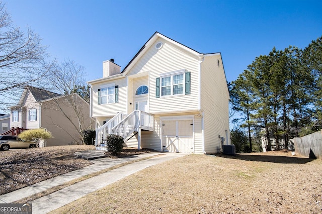 split foyer home featuring central AC, driveway, a chimney, and an attached garage