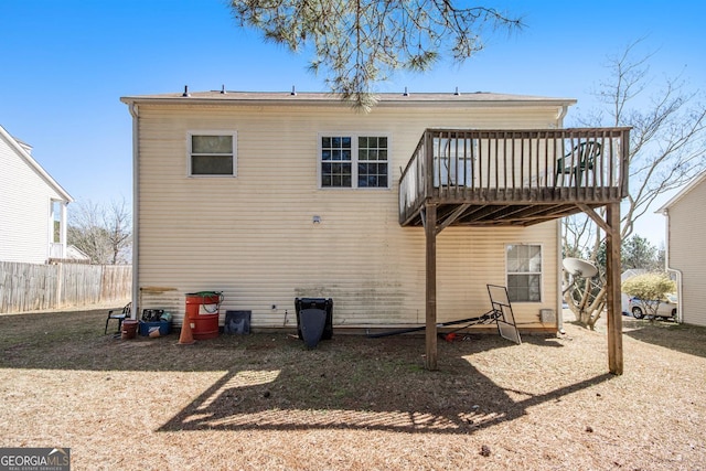 back of property with fence and a wooden deck