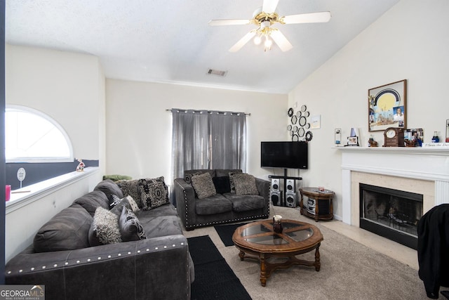 carpeted living room featuring a ceiling fan, lofted ceiling, visible vents, and a fireplace