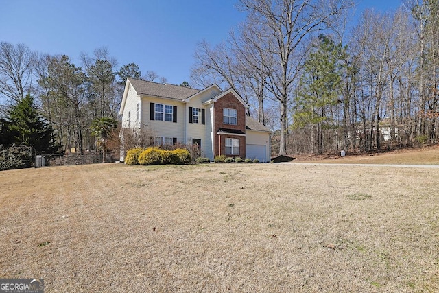 view of front of house with a garage, brick siding, and a front lawn