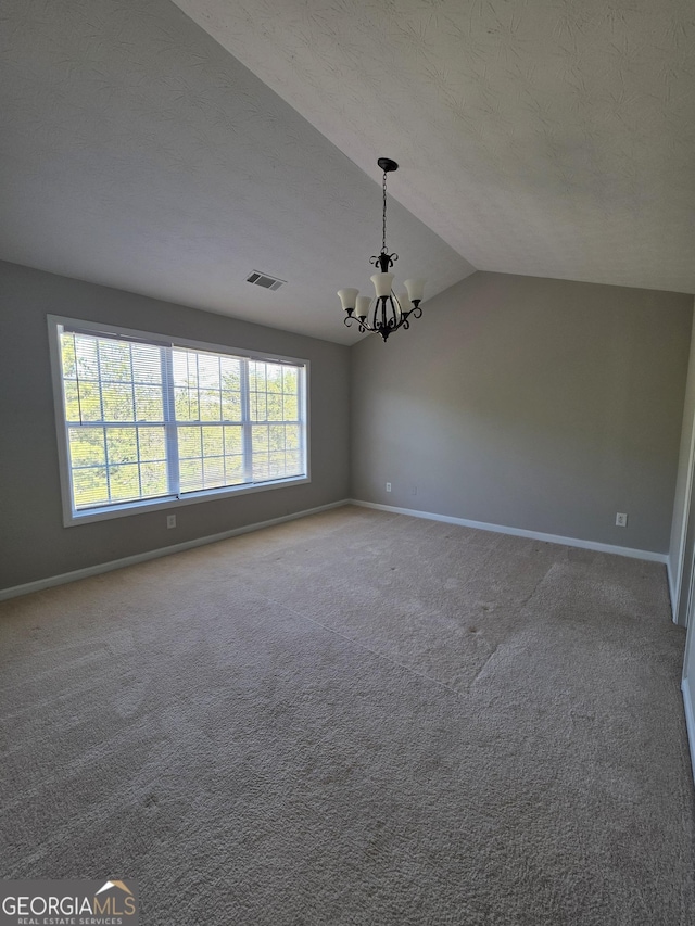 carpeted spare room with visible vents, a notable chandelier, and baseboards