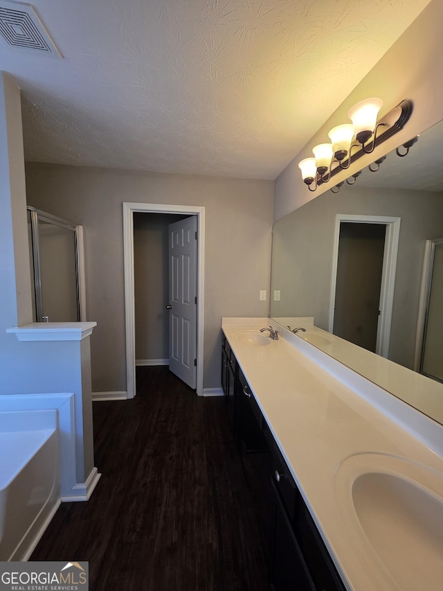 bathroom featuring visible vents, a sink, and wood finished floors