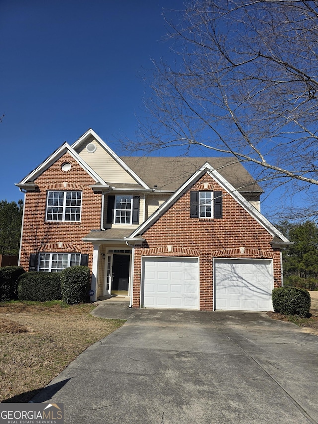 traditional home with an attached garage, concrete driveway, and brick siding