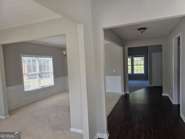 corridor featuring wainscoting and wood finished floors