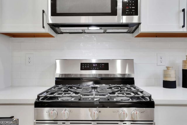 kitchen with light countertops, appliances with stainless steel finishes, backsplash, and white cabinetry