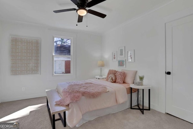 bedroom with carpet floors, crown molding, baseboards, and ceiling fan