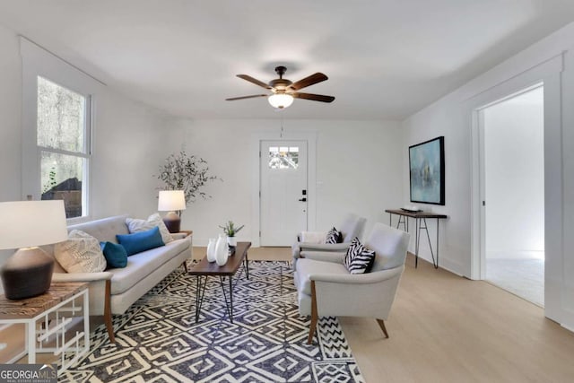 living area with light wood-type flooring and a ceiling fan