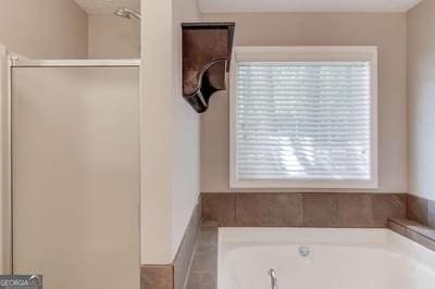 bathroom featuring a shower and a bath