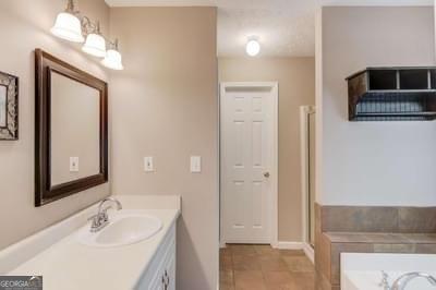 full bath with a garden tub and vanity