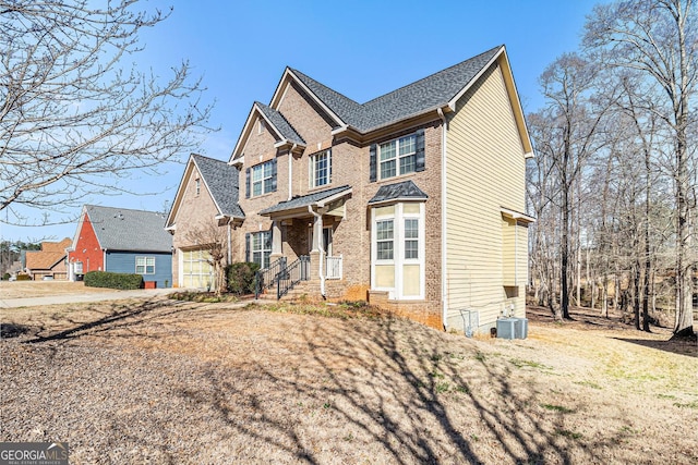 view of front of home featuring a garage, central AC, and brick siding