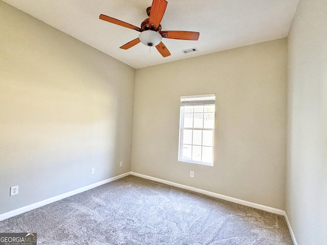 spare room with ceiling fan, carpet floors, visible vents, and baseboards