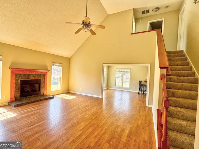 unfurnished living room featuring stairs, light wood-style floors, and a healthy amount of sunlight