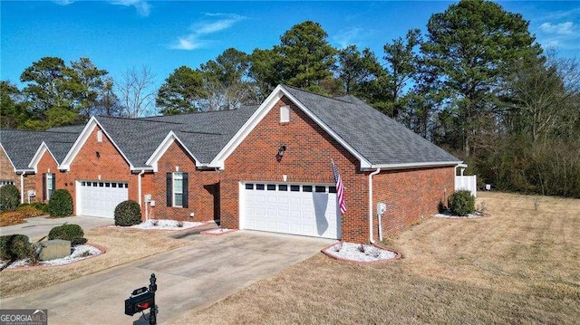 view of front facade with a garage, concrete driveway, brick siding, and a front lawn