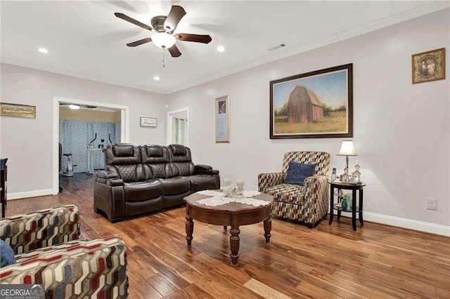 living room with crown molding, baseboards, ceiling fan, and wood finished floors