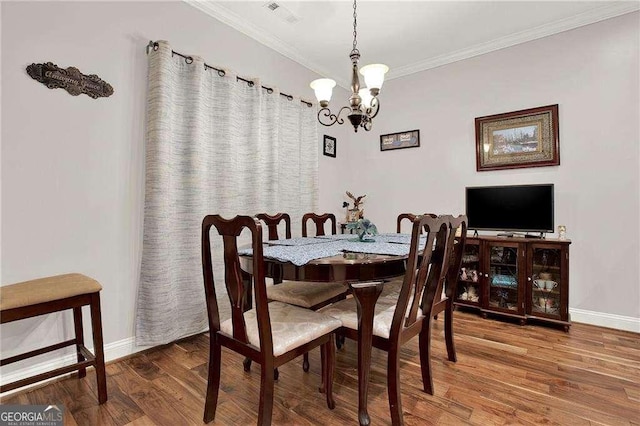 dining area featuring ornamental molding, wood finished floors, visible vents, and baseboards