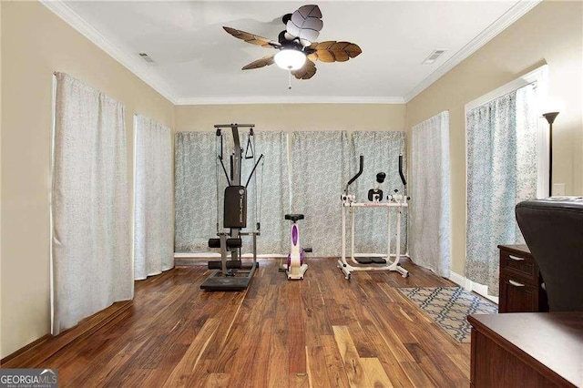 workout room featuring wood finished floors, visible vents, and crown molding