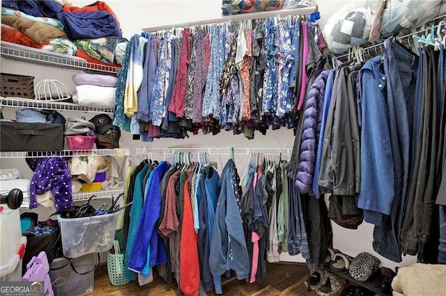 walk in closet with wood finished floors