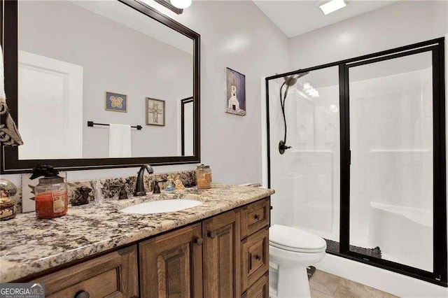 bathroom featuring toilet, tile patterned flooring, a shower stall, and vanity