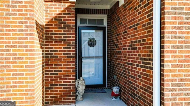 view of exterior entry with brick siding