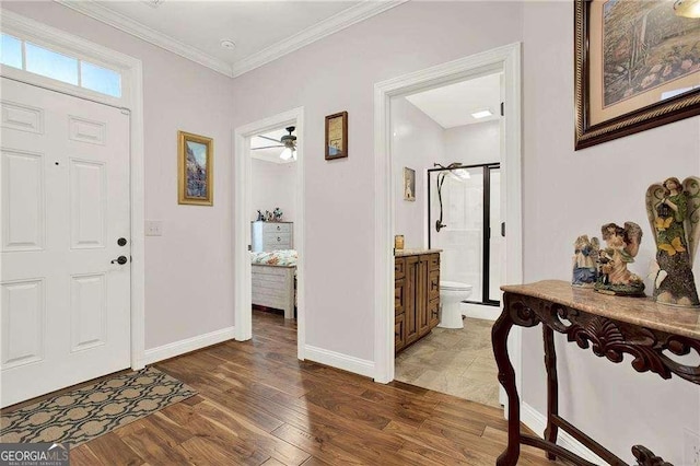 entrance foyer featuring baseboards, ornamental molding, and wood finished floors