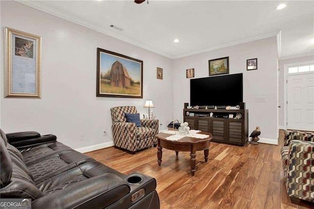 living area featuring baseboards, crown molding, and wood finished floors