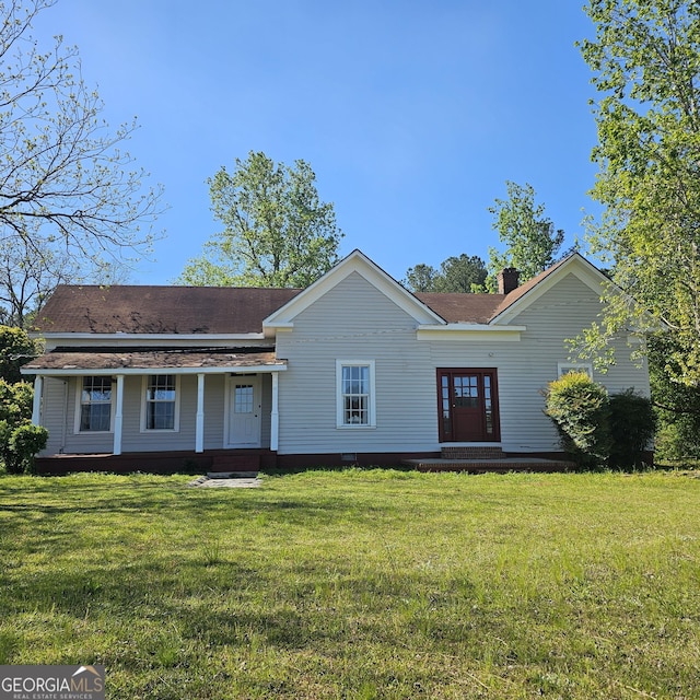 ranch-style house featuring a chimney and a front yard