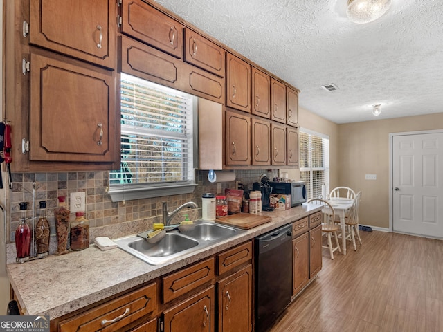 kitchen with a sink, decorative backsplash, brown cabinetry, and dishwasher