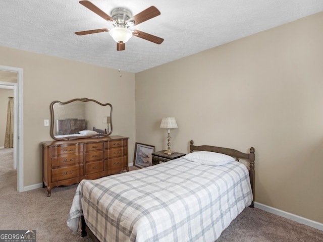 carpeted bedroom with ceiling fan, baseboards, and a textured ceiling