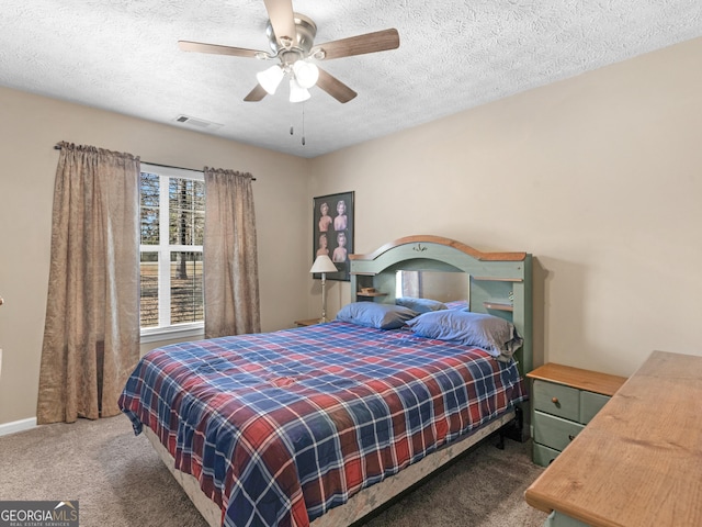 carpeted bedroom with visible vents, ceiling fan, a textured ceiling, and baseboards