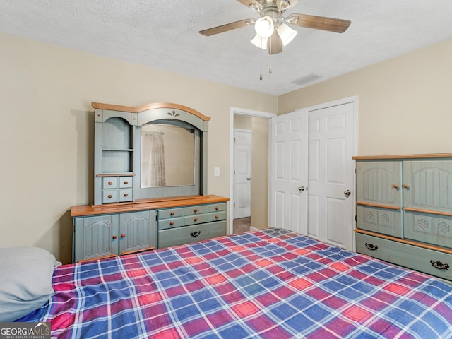 unfurnished bedroom with a ceiling fan, visible vents, and a textured ceiling