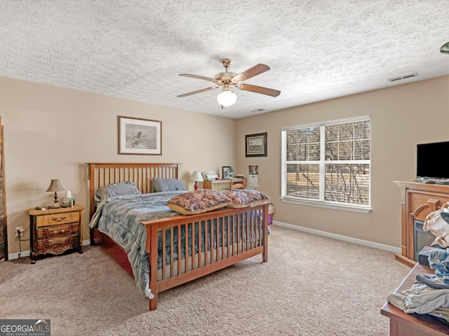 bedroom with carpet floors, visible vents, a textured ceiling, and baseboards