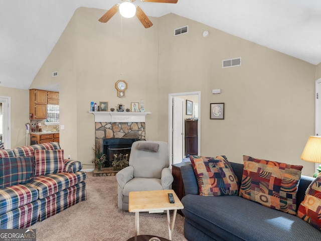 carpeted living room featuring high vaulted ceiling, a fireplace, visible vents, and a ceiling fan