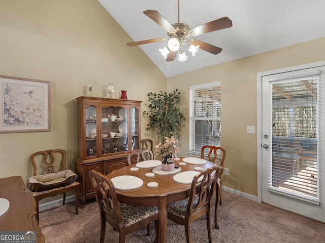 dining area featuring a ceiling fan, light colored carpet, high vaulted ceiling, and baseboards