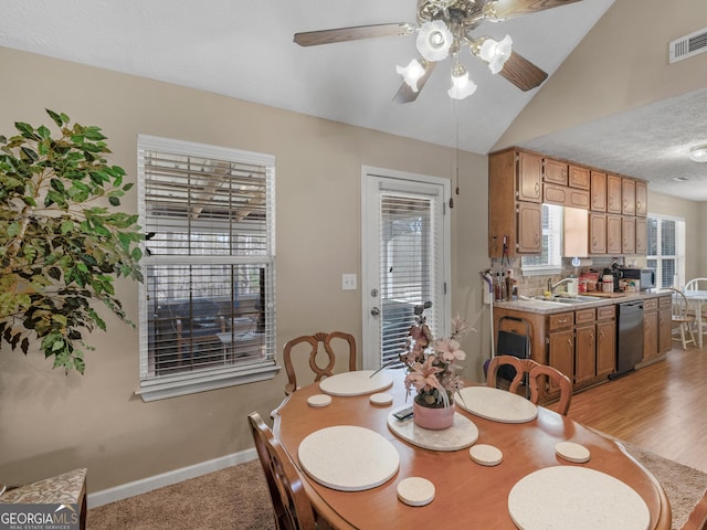 dining area with a textured ceiling, a ceiling fan, visible vents, vaulted ceiling, and baseboards