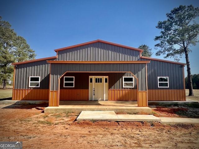 view of front facade with covered porch, board and batten siding, and a detached garage