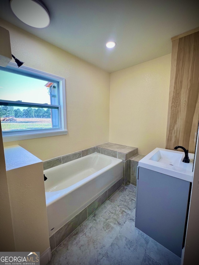 bathroom with vanity and a bath