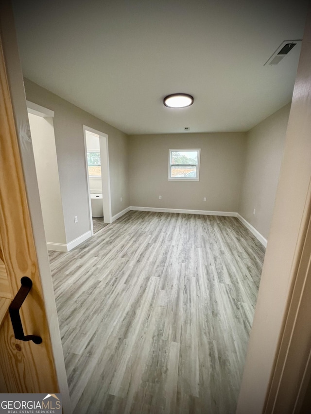 empty room featuring visible vents, baseboards, and wood finished floors