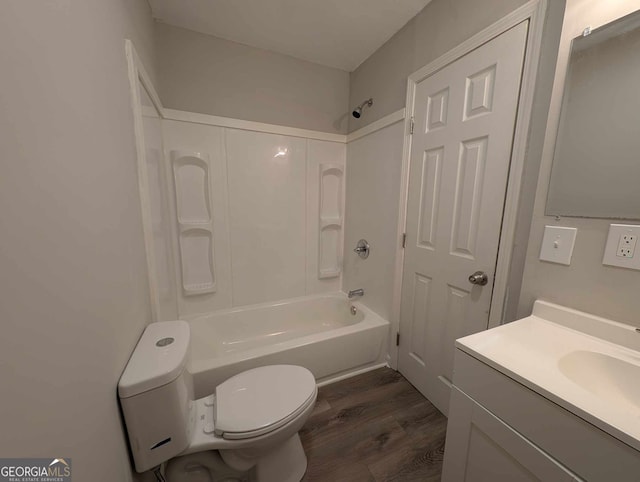 bathroom featuring toilet, shower / washtub combination, wood finished floors, and vanity