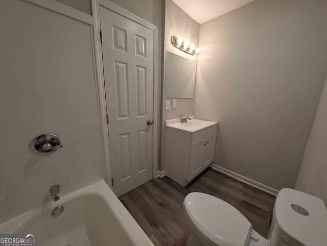 bathroom featuring wood finished floors, vanity, toilet, and baseboards