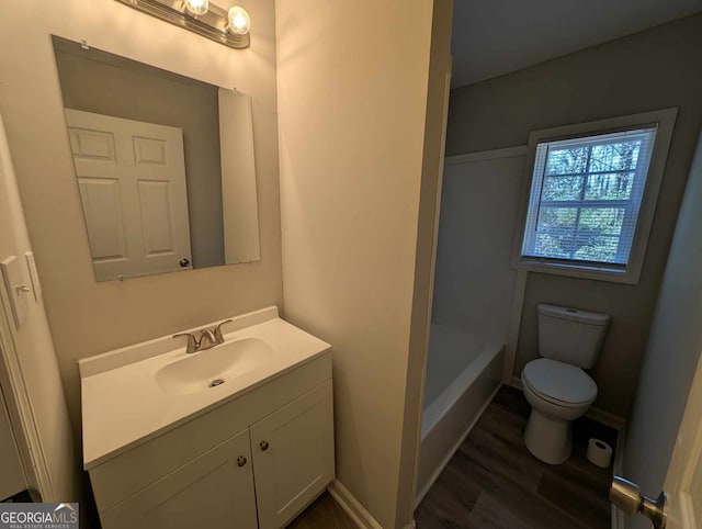 full bath featuring wood finished floors, vanity, toilet, and baseboards