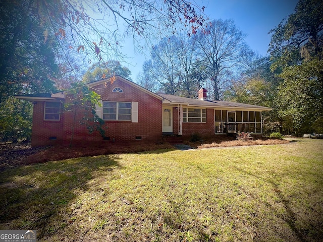 rear view of house with crawl space, brick siding, a lawn, and a chimney