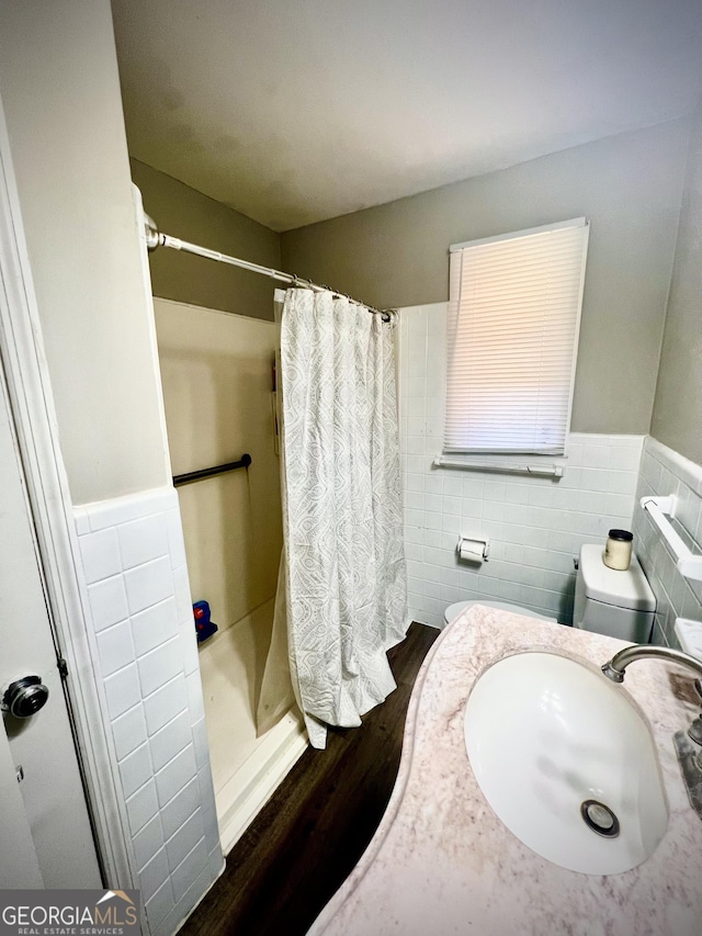 bathroom with curtained shower, a sink, and tile walls