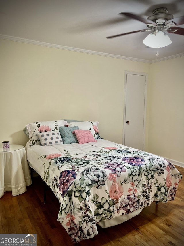 bedroom with ornamental molding, wood finished floors, and a ceiling fan