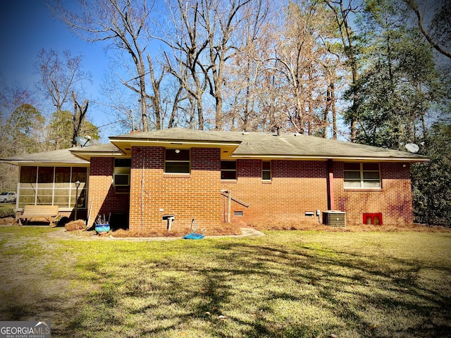 rear view of property featuring brick siding, crawl space, and a lawn