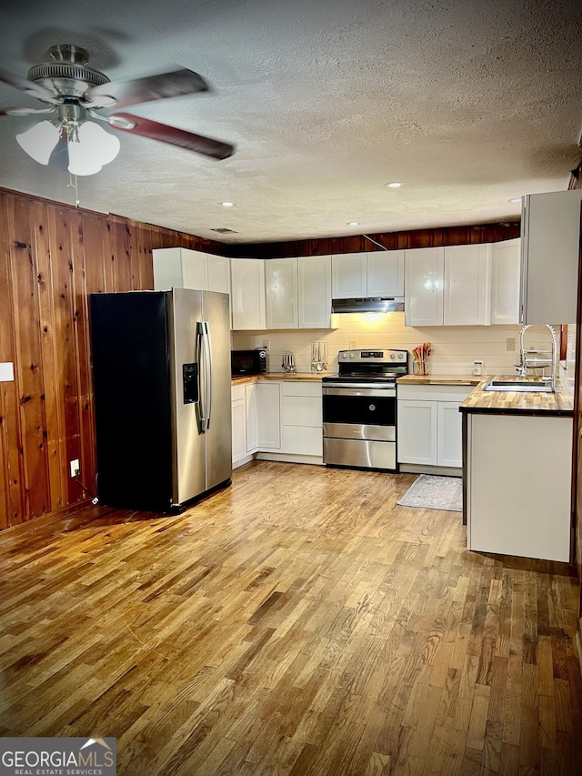 kitchen featuring white cabinets, stainless steel appliances, a textured ceiling, light wood-style floors, and a sink