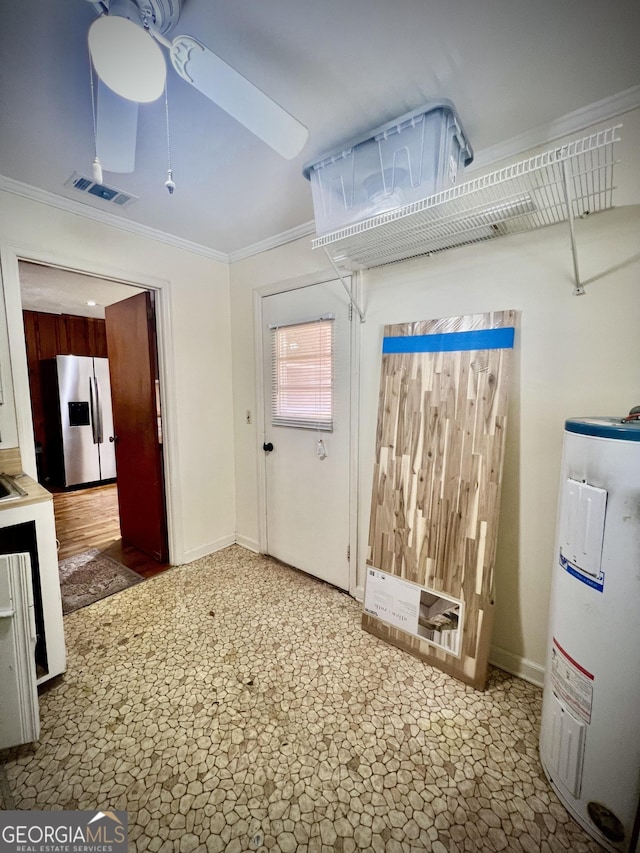 interior space with baseboards, visible vents, a ceiling fan, ornamental molding, and water heater